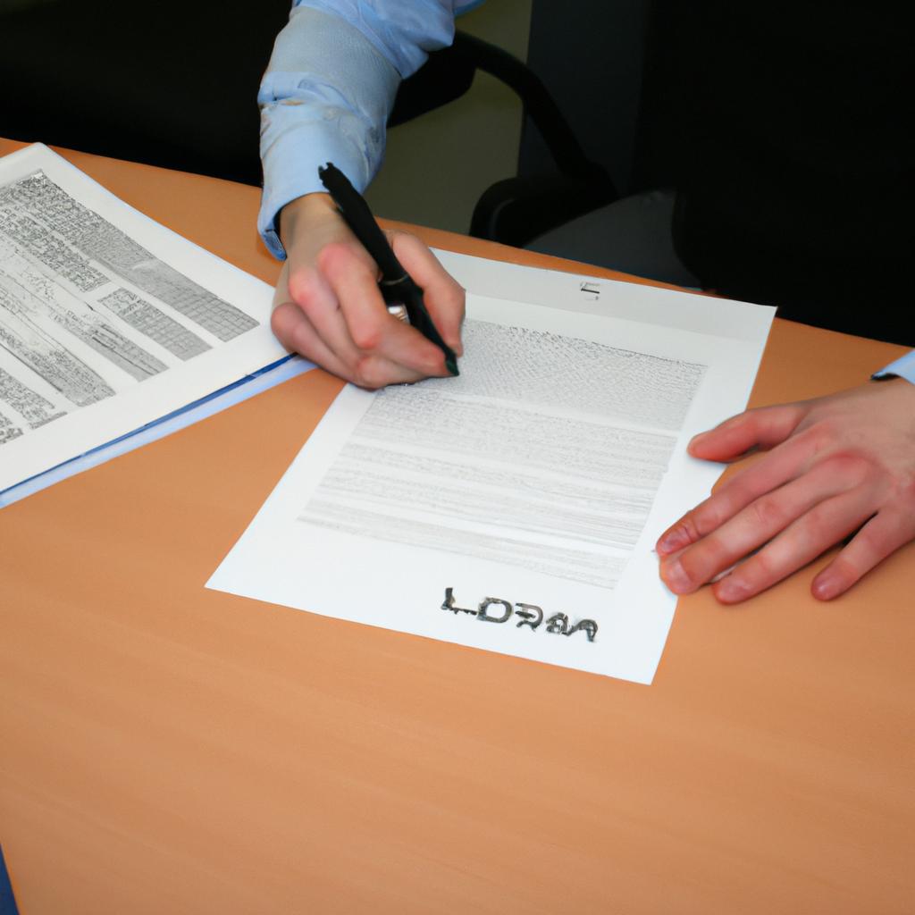 Person signing loan documents at desk